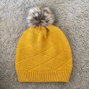 bright yellow hat with fur ball
